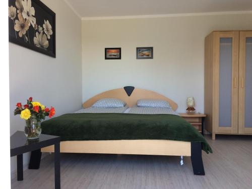 sypialnia z łóżkiem i wazonem kwiatów na stole w obiekcie Centuria Domek Letniskowy we Władysławowie