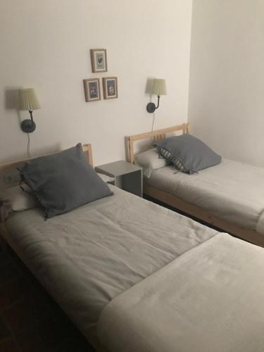 コルドバにあるApartamento Completo Santa Marinaのベッド2台 壁にランプ2つが備わる客室です。