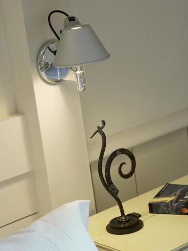 a lamp sitting on a table next to a bed at Villa Cécile in Yvoire