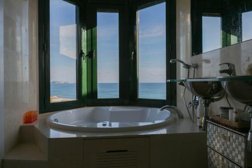 ein Badezimmer mit einer großen Badewanne und Meerblick in der Unterkunft 2 bedroom apartment in Sa Punta, Begur- Sea views, terrace, pool and access to the beach (Ref:H29) in Begur