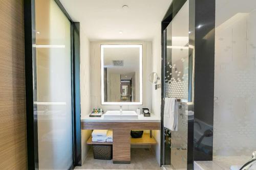 a bathroom with a sink and a mirror at Hampton by Hilton Zhengzhou High-Tech Zone in Zhengzhou