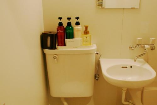 a bathroom with a toilet with bottles on top of it at Hotel Peace (Adult Only) in Tokyo