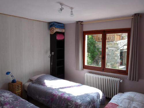 a bedroom with two beds and a window at Chalet Le Bois Noir in Valdeblore