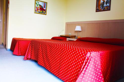 a bed with a red and white polka dot table cloth at Hotel Cristallo in Lignano Sabbiadoro