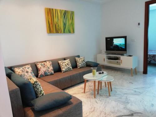 ein Wohnzimmer mit einem Sofa und einem TV in der Unterkunft FLAT JINEN DU LAC 2 in Tunis