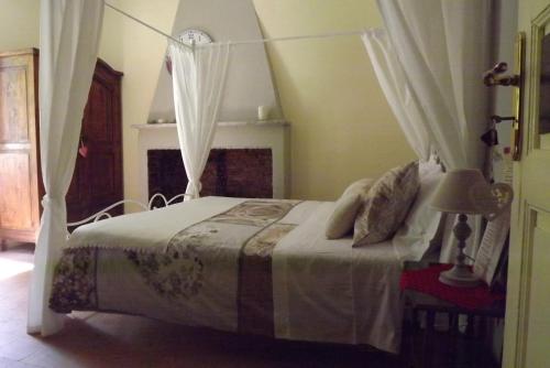 a bedroom with a white bed with a canopy at B&B Il Tempo Del Vento in front of the Castle in Tresana