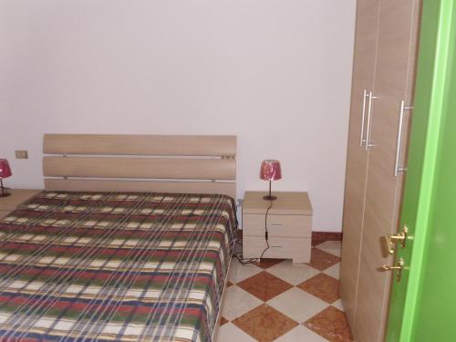 1 dormitorio con 1 cama y 1 mesa con lámpara en Residenza Graziella, en Cavedago