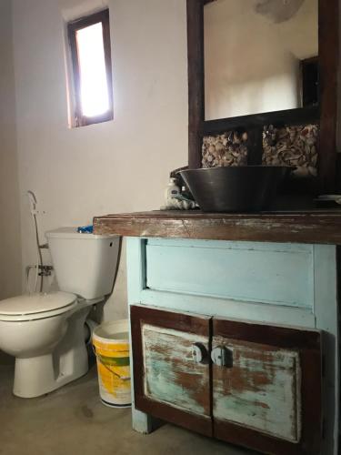 W łazience znajduje się toaleta, umywalka i lustro. w obiekcie Cabaceira Village w mieście Cabaceira Pequena