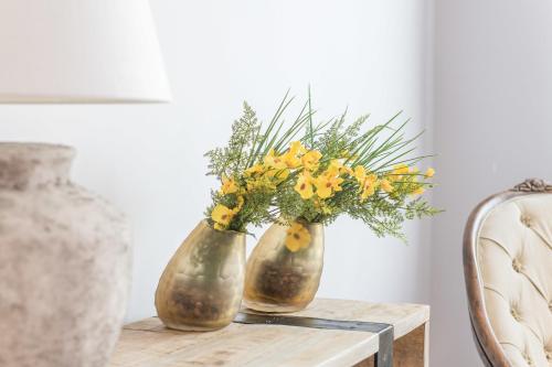 two vases with flowers sitting on a table at BYPILLOW Velázquez 45 in Madrid