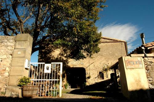 een witte poort voor een gebouw bij Chambre d'Hôtes la Poterie in Caunes-Minervois