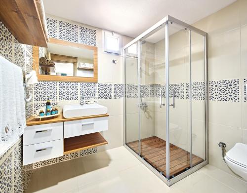 y baño con ducha y lavamanos. en Fİ Light Solto Boutique Beach Hotel, en Selimiye