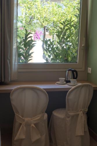 two chairs sitting at a table looking out a window at L'Albero in Porto Empedocle
