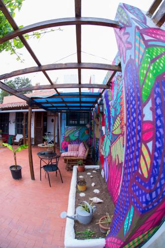 a covered patio with a painting on the wall at Patio Hostel in La Laguna