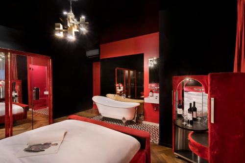 a red and black bathroom with a tub and a sink at Dave Gordon, a member of Brown Hotels in Tel Aviv