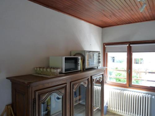 a microwave on a wooden cabinet in a room with a window at Chalet Le Bois Noir in Valdeblore