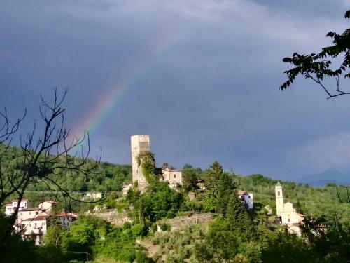 a rainbow over a castle on a hill at B&B Il Tempo Del Vento in front of the Castle in Tresana