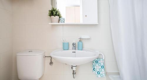 a white bathroom with a toilet and a sink at Residencia Universitaria Resa Colegio de Cuenca in Salamanca