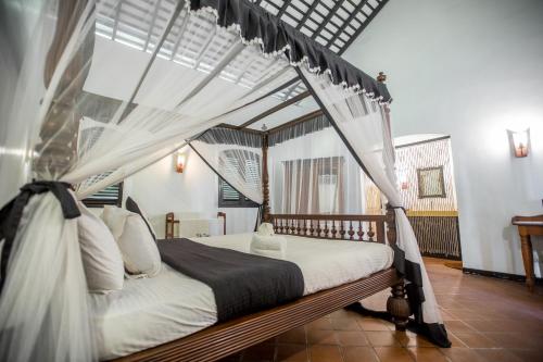 a bedroom with a bed with a canopy at Villa Tissa Beach Resort in Weligama