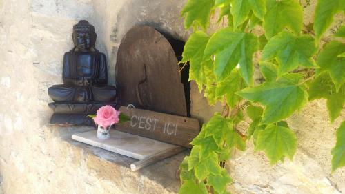 a small statue sitting on a wall with a sign at Lou Souleu in Sisteron