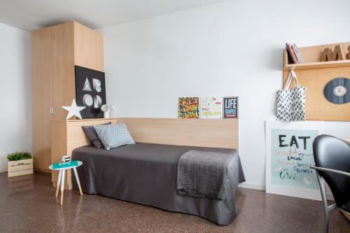 um quarto com uma cama, uma secretária e uma cadeira em Residencia Universitaria Colegio de Cuenca em Salamanca