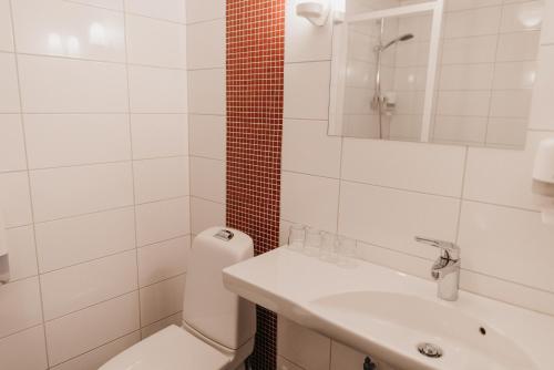 a white bathroom with a toilet and a sink at Tärnaby Fjällhotell in Tärnaby