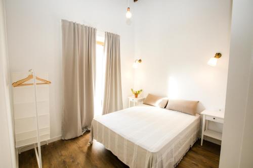 a white bedroom with a bed and a window at Denia Loft in Denia