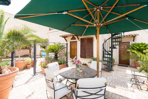 un tavolo con ombrellone verde su un patio di Hotel Celio a Roma