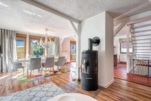 a living room with a fireplace and a dining room at Haus Kieferngrund in Ahlbeck