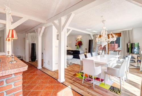 uma sala de jantar e sala de estar com uma mesa branca e cadeiras em Haus Kieferngrund em Ahlbeck