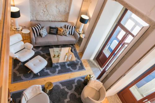 vistas panorámicas a una sala de estar con sofá y sillas en Oporto Golden Apartment, en Oporto