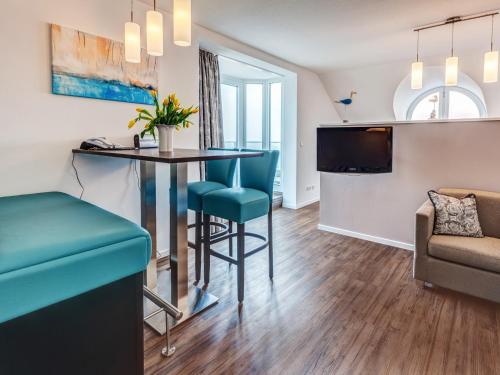 a living room with a table and chairs and a couch at Ostsee-Hotel in Großenbrode