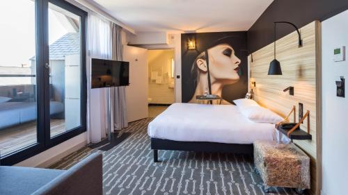 a hotel room with a bed and a large window at ibis Styles Laval Centre Gare in Laval