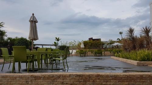 a patio with tables and chairs and an umbrella at Mactan Newtown Ocean View 360 Degree in Mactan