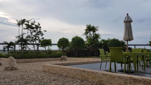 a patio with a table and chairs and an umbrella at Mactan Newtown Ocean View 360 Degree in Mactan