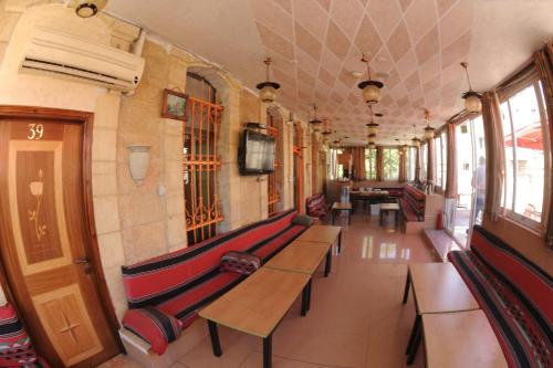 a hallway with benches and tables in a building at Palm Hostel in Jerusalem
