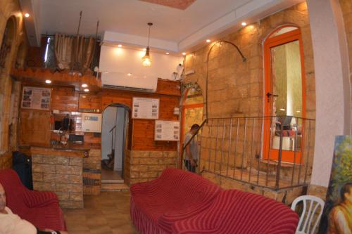 sala de estar con sillas rojas y cocina en Palm Hostel en Jerusalén