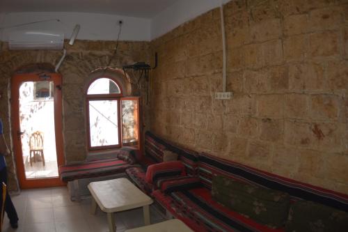 a living room with a couch and a window at Palm Hostel in Jerusalem
