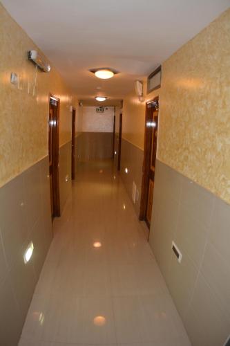 an empty hallway in a building with doors and tiles at Palm Hostel in Jerusalem