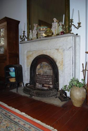 a living room with a white fireplace with at Glenfield Plantation Historic Antebellum Bed and Breakfast in Natchez