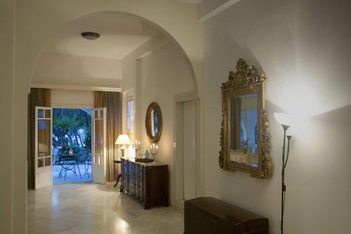 a hallway with a mirror and a table with a lamp at Doukissa in Parikia