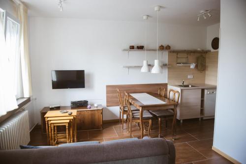 ein Wohnzimmer mit einem Tisch und einer Küche in der Unterkunft Stan u samom centru Obrenovca, na Trgu in Obrenovac