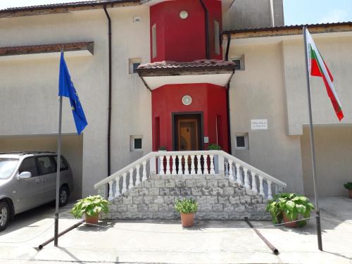 un edificio con una puerta roja y una bandera en Villa Sunny Hill, en Fish Fish