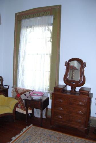 a living room with a dresser and a mirror at Glenfield Plantation Historic Antebellum Bed and Breakfast in Natchez