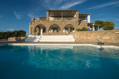 a house with a swimming pool in front of a building at Terra in Parikia