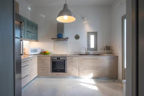 a kitchen with wooden cabinets and a sink at Terra in Parikia