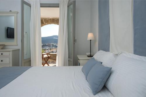 a bedroom with a large white bed with a window at Terra in Parikia