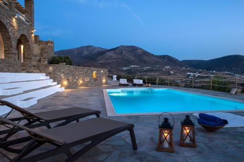a swimming pool with lounge chairs next to a building at Terra in Parikia