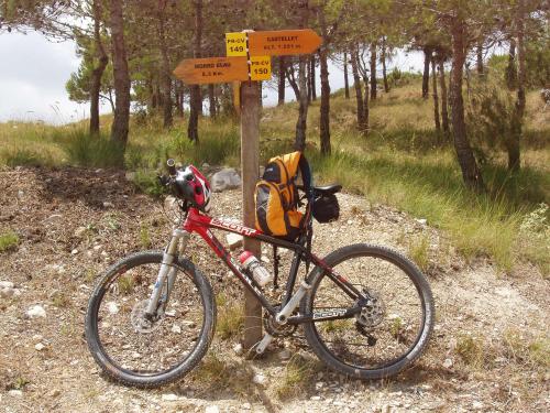 a bike parked next to a sign on a trail at LA MUNTANYA - Apartamentos Rural Guadalest in Benimantell