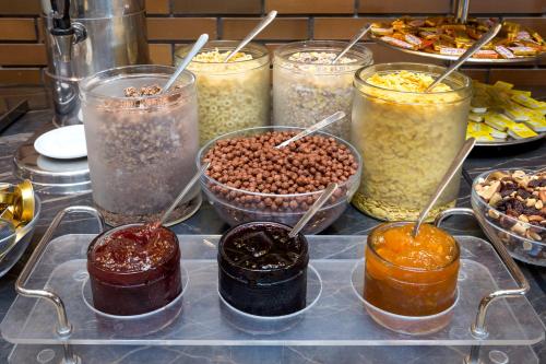 a bunch of different kinds of food in jars at Marmara Hotel Budapest in Budapest