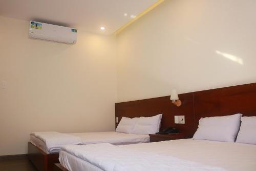 a hotel room with two beds and a fan at My Ca Hotel in Cam Ranh